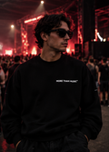 Model wearing a black crew-neck sweatshirt with small white More Than Music chest lettering